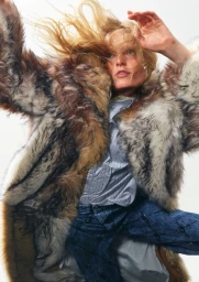 Model Hanne Gaby Odiele wearing a textured faux fur coat and blue jeans against a plain white background for Des Phemmes.