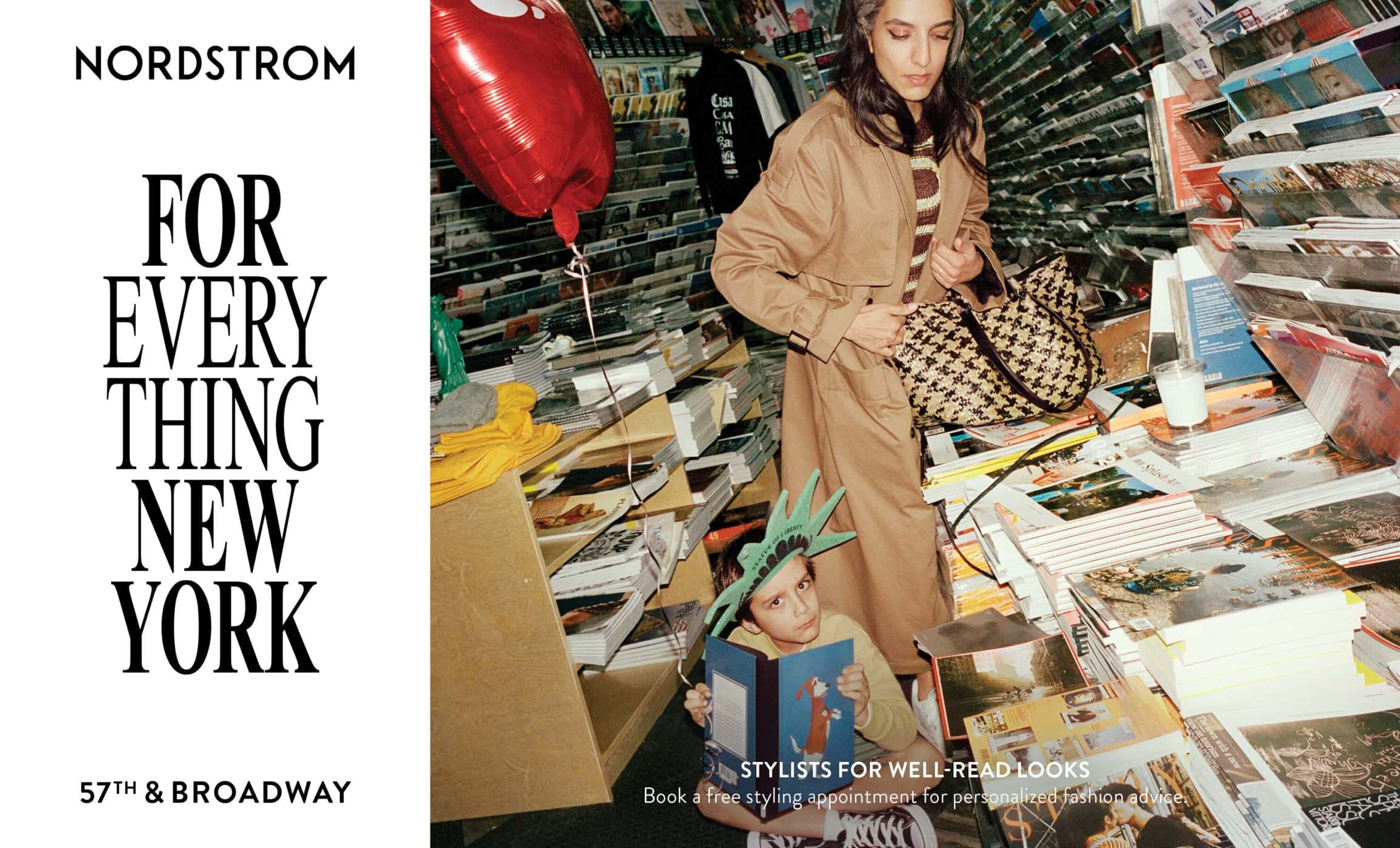 Fashion editorial featuring a stylish woman, a child wearing a Statue of Liberty hat reading a book, and a red balloon, surrounded by magazines.