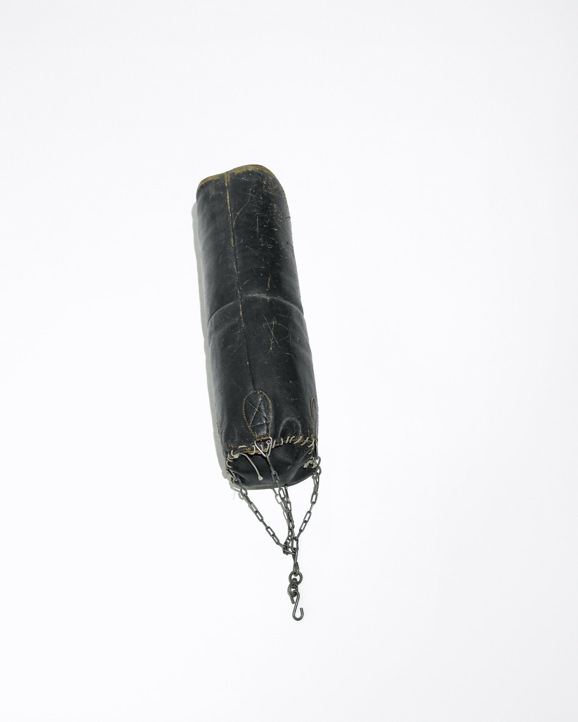 Cylindrical black leather pouch with drawstring and chain, isolated against a plain white background in a product style shot.