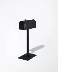 Black mailbox on a stand with a raised red flag against a white background
