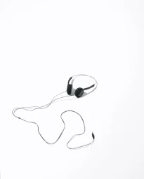 Black wired headphones with a long snaking cable resting on a bright white background