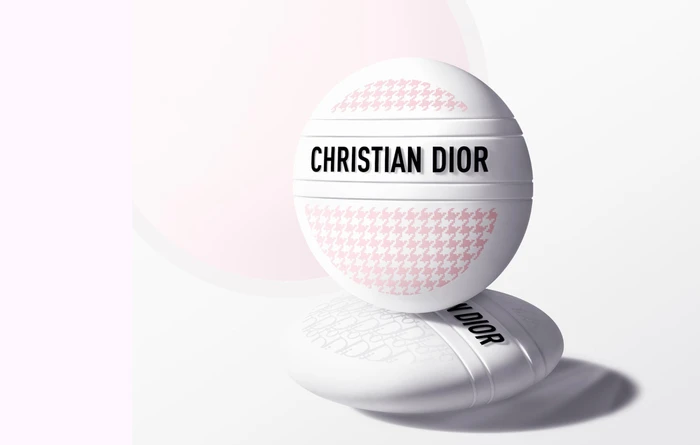 Two spherical Dior Le Baume skincare product containers stacked against a clean white seamless studio background.
