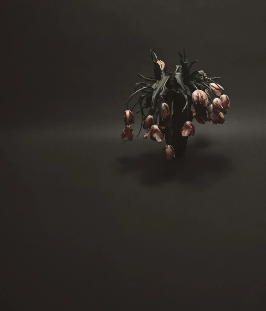 Still life photograph of a bouquet of drooping, dried tulips with pink petals in a vase against a dark, solid-color background.