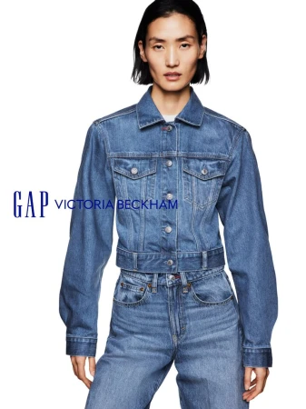 Model wearing a blue denim jacket and matching jeans against a solid white background for Gap x Victoria Beckham