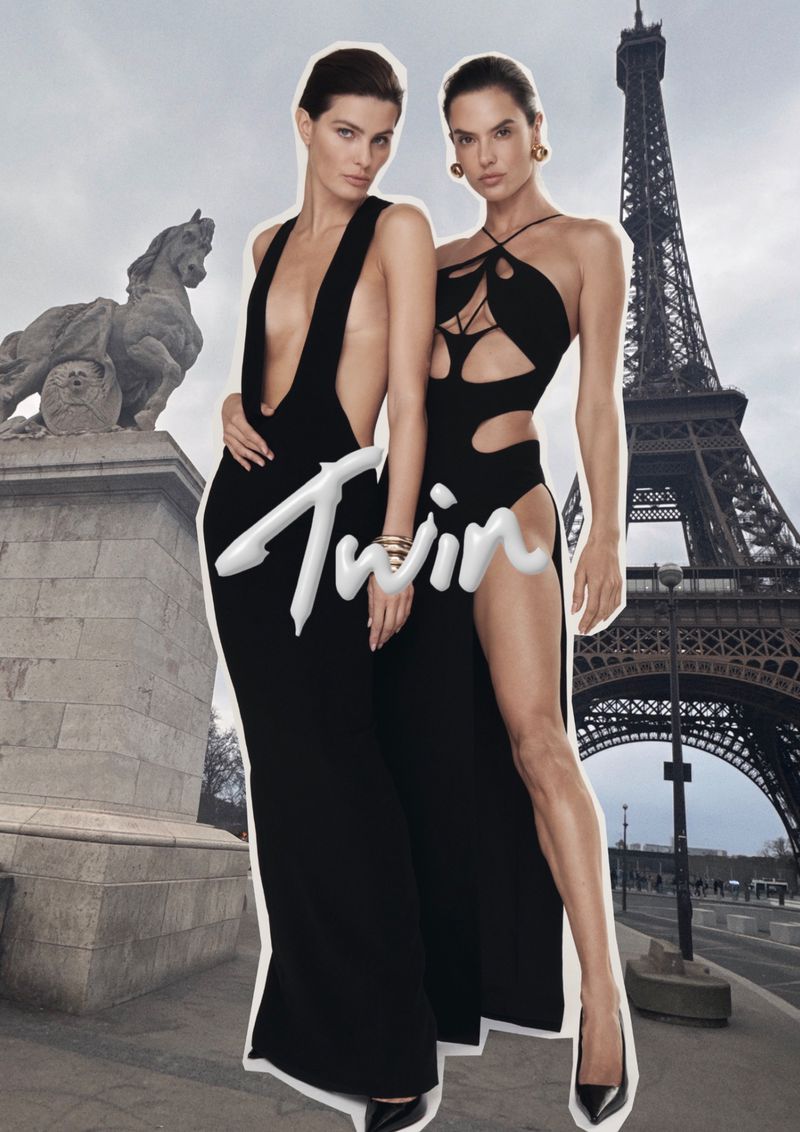 Two fashion models pose in black gowns in Paris, France, with the Eiffel Tower in the background. Elegant fashion editorial shot.