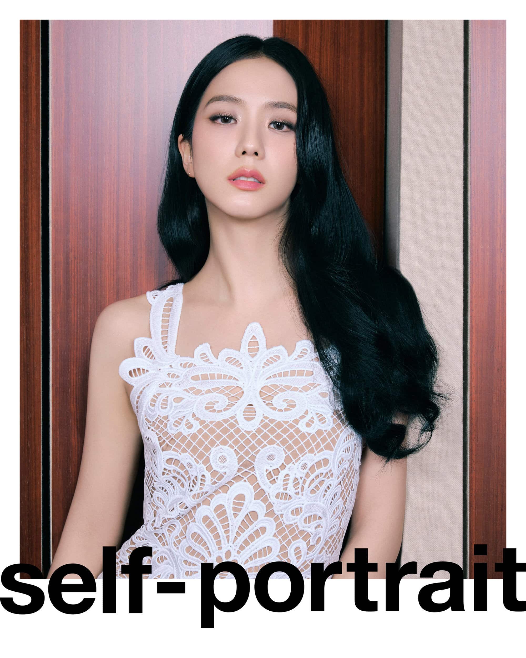 Portrait of a woman with long black hair wearing a white lace top in front of a wood-paneled wall. Beauty and fashion photography.