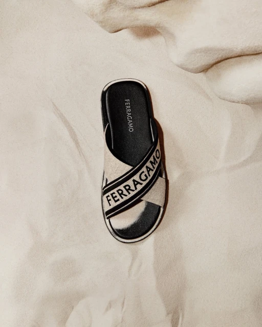 Ferragamo slide sandal on a white textile background in a neutral colour palette, highlighting fashion footwear.