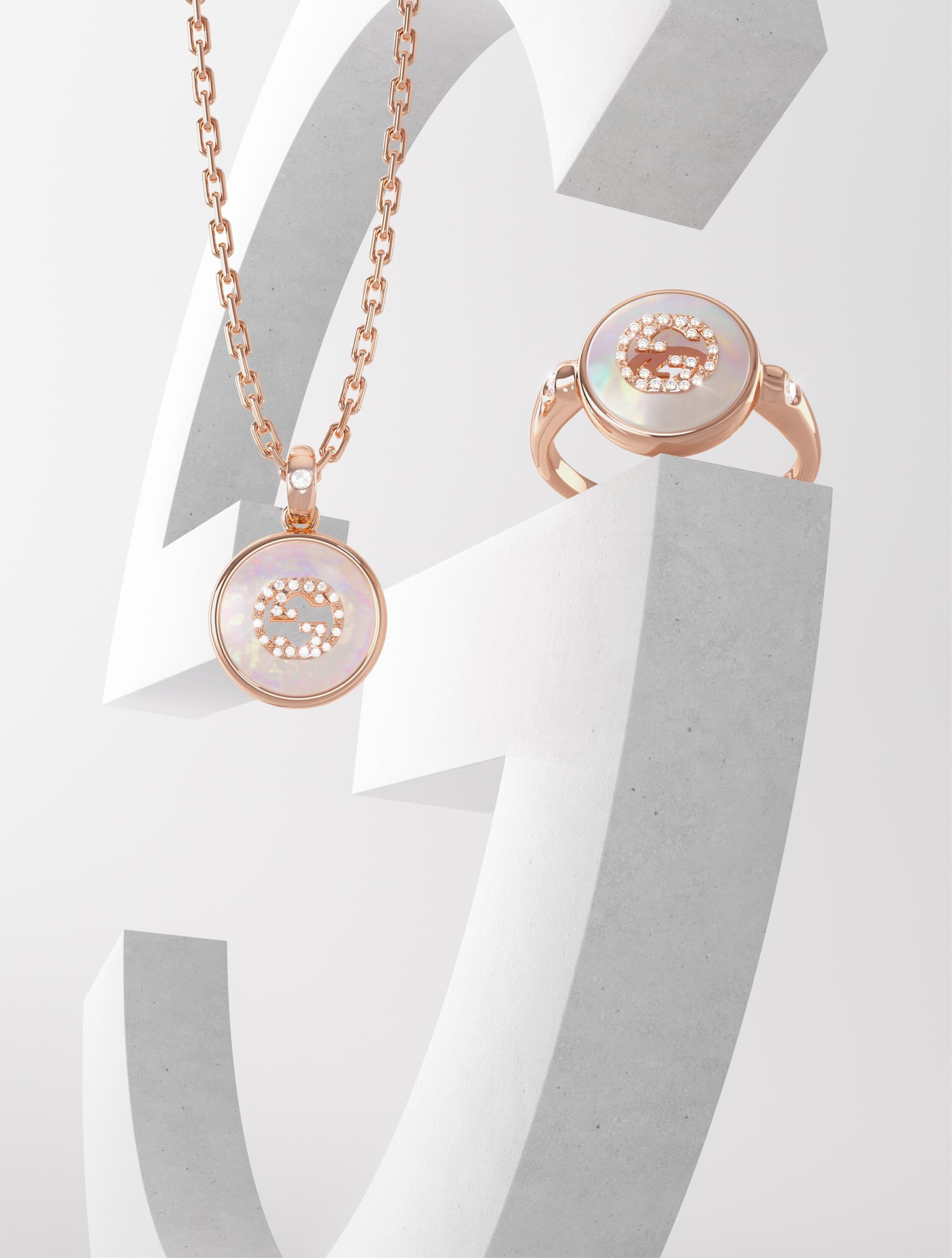 Elegant rose gold necklace and ring featuring mother-of-pearl in a white studio setting, showcasing luxury jewelry with a minimalist aesthetic.