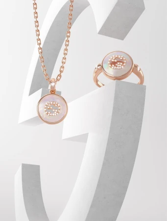 Elegant rose gold necklace and ring featuring mother-of-pearl in a white studio setting, showcasing luxury jewelry with a minimalist aesthetic.