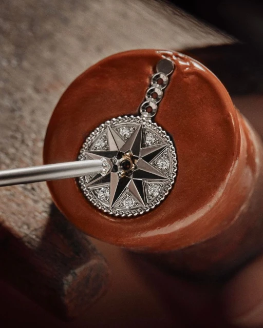 Close-up of a detailed star pendant with diamond accents set on a brown surface, showcasing jewelry craftsmanship and design.