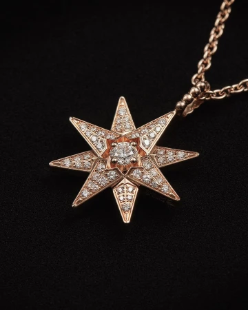 Close-up of a rose gold pendant necklace featuring a starburst design with diamonds on a black background; jewelry advertisement.