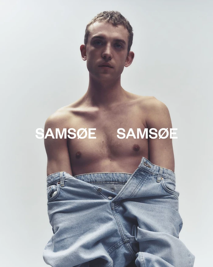 Shirtless man wearing light blue denim jeans pulled low against a plain white studio background