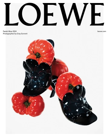 Loewe fashion ad featuring glossy black high heels with red tomato accents against a stark white background, text overlay.