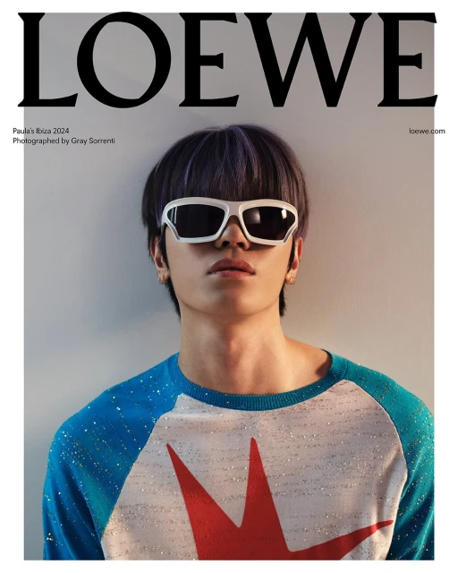 Magazine cover featuring a model wearing sunglasses and a star patterned top against a neutral backdrop, showcasing a Loewe advertisement.