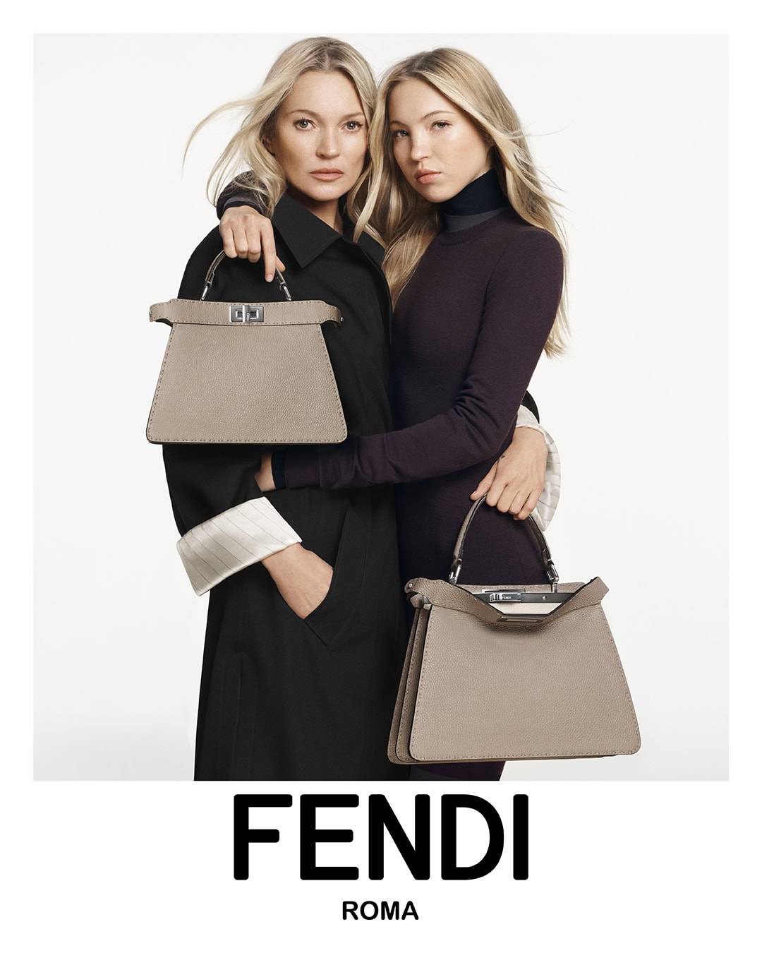 Fashion shot of Kate Moss and Lila Moss modeling Fendi handbags in a studio, both posing in black attire against a white background.