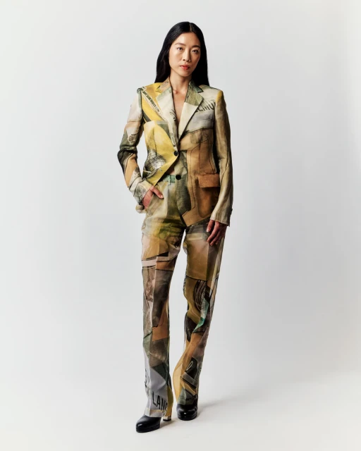 Asian woman posing in a fashionable printed blazer and pants suit against a clean white background in a full-length studio shot.