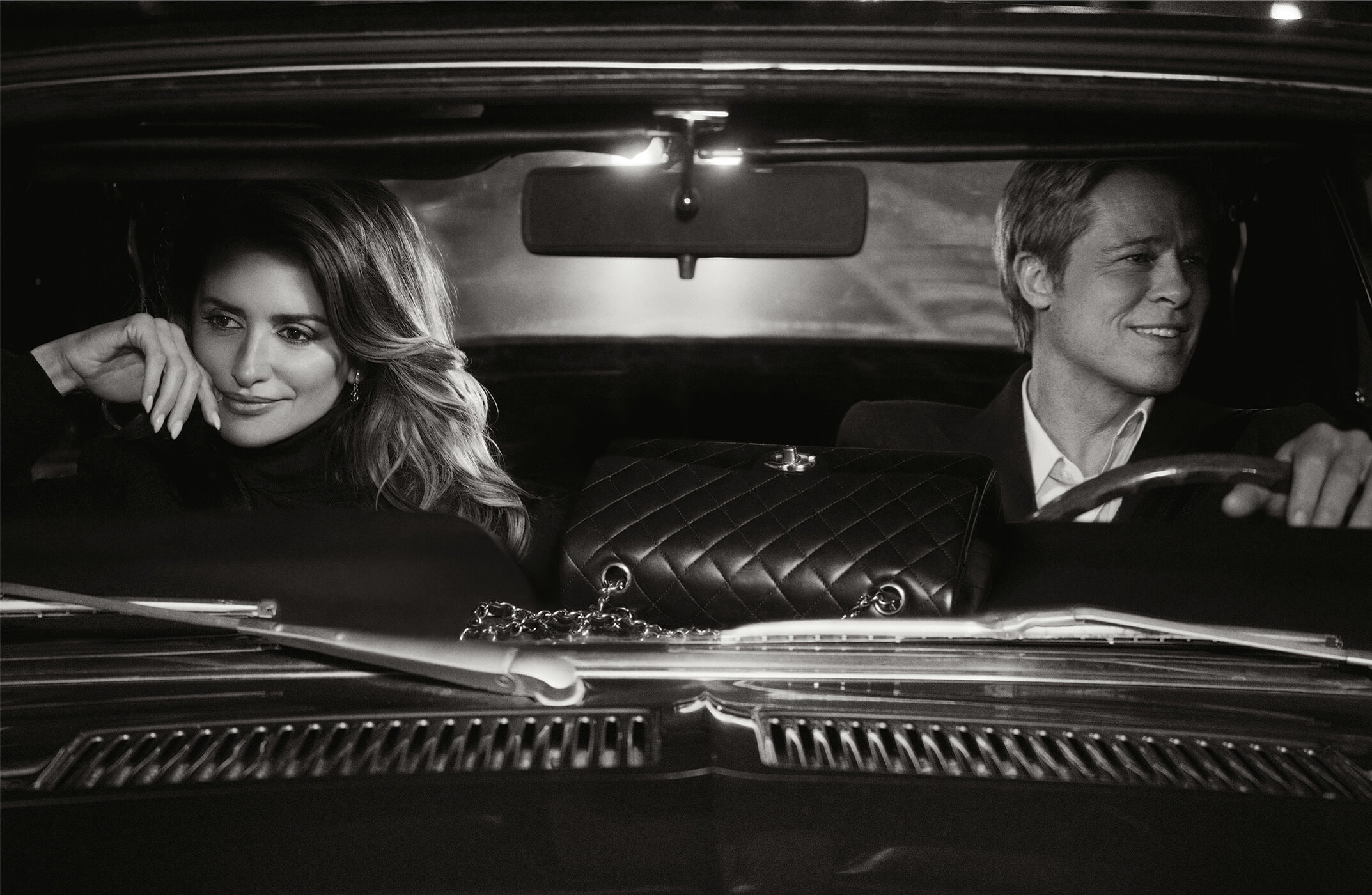 Penelope Cruz and Brad Pitt inside a classic car; quilted Chanel bag sits between them on the front seat in black and white.