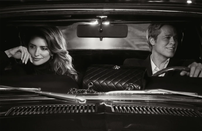 Penelope Cruz and Brad Pitt inside a classic car; quilted Chanel bag sits between them on the front seat in black and white.