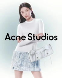 Woman wearing a white top and denim skirt holding a white handbag with Acne Studios text overlay in front of a soft gradient background.