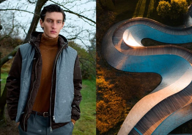 Fashion shot of a young adult male model wearing a brown turtleneck and vest outdoors with a winding path in the background.