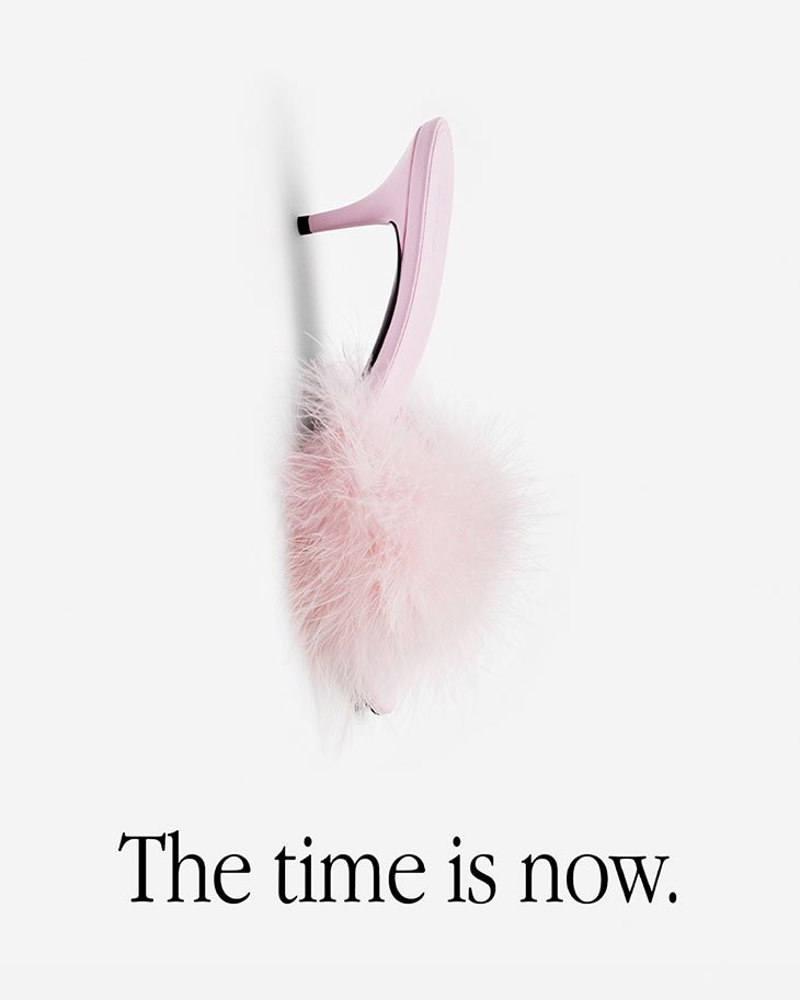 Elevated view of a pink heeled sandal with fluffy pink fur accent, showcased against a clean white backdrop. Studio shot of women's shoe.