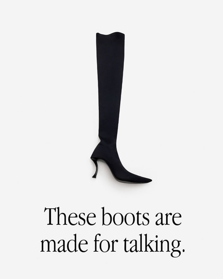 Studio shot of a single black, high-heeled, over-the-knee boot on a white background, alongside the text 'These boots are made for talking.'