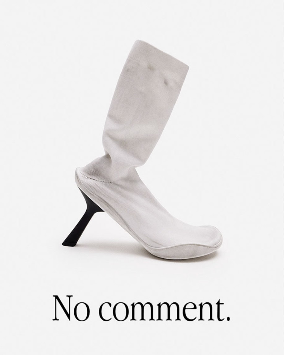 Elevated white sock boot with a black heel against a white background. A fashion-forward statement piece with a minimalist aesthetic.