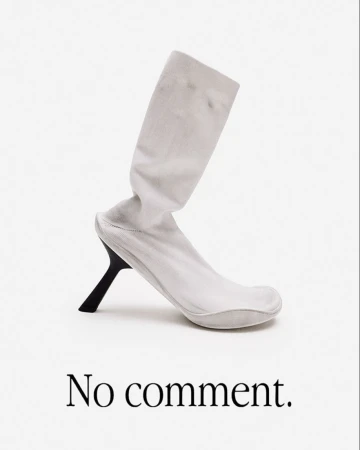 Elevated white sock boot with a black heel against a white background. A fashion-forward statement piece with a minimalist aesthetic.