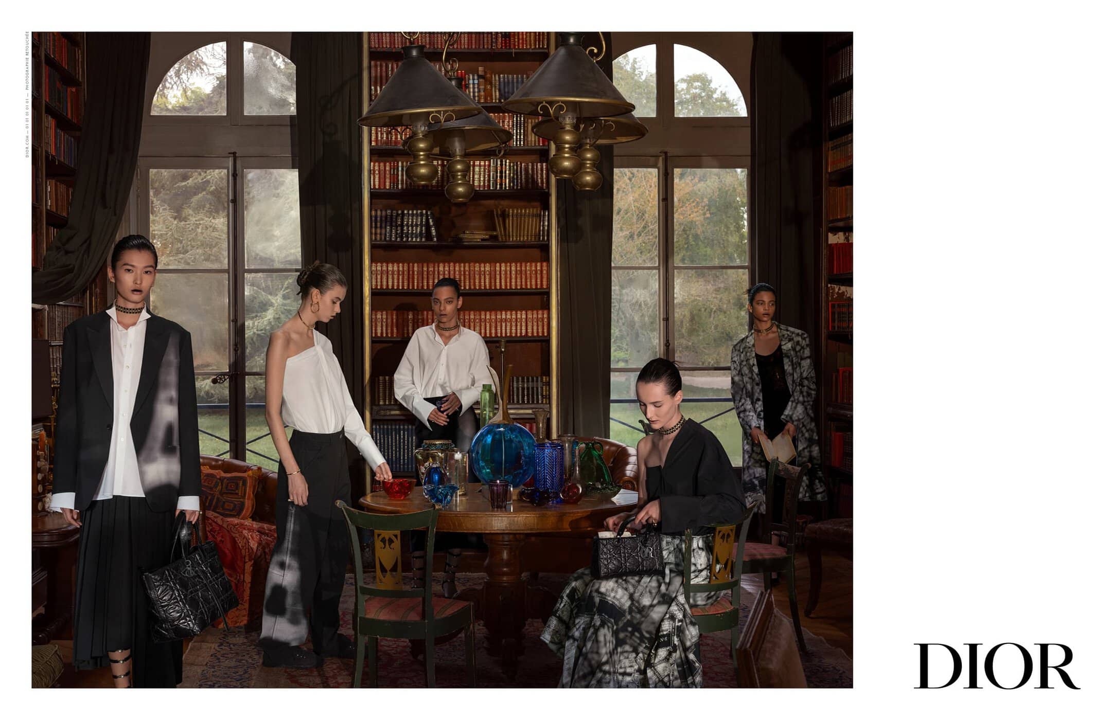 Fashion editorial shot inside an opulent home library features five slender fashion models wearing designs with splashes of tie-dye print.
