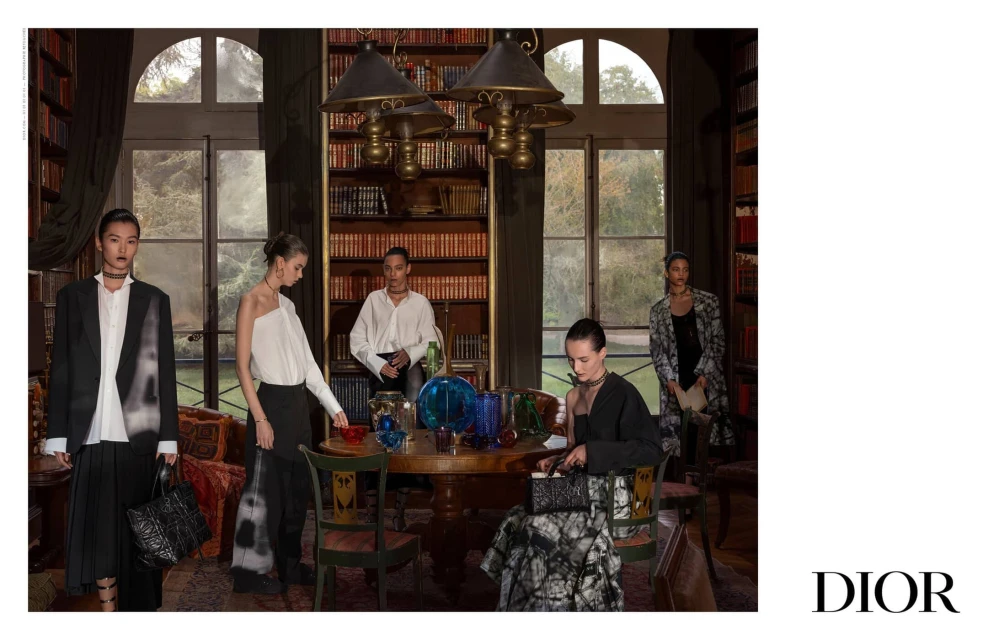 Fashion editorial shot inside an opulent home library features five slender fashion models wearing designs with splashes of tie-dye print.