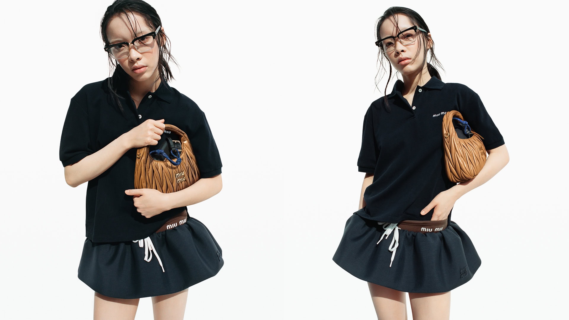 A young Asian woman wearing glasses, a dark polo shirt, and a skirt is holding a leather Miu Miu handbag against a clean, white background.