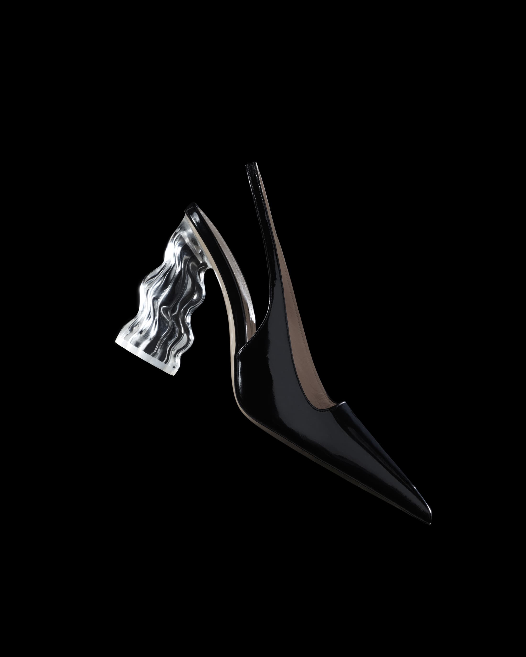 Elegant black slingback heel featuring a transparent, sculpted heel, set against a stark black backdrop. Fashion-forward footwear.