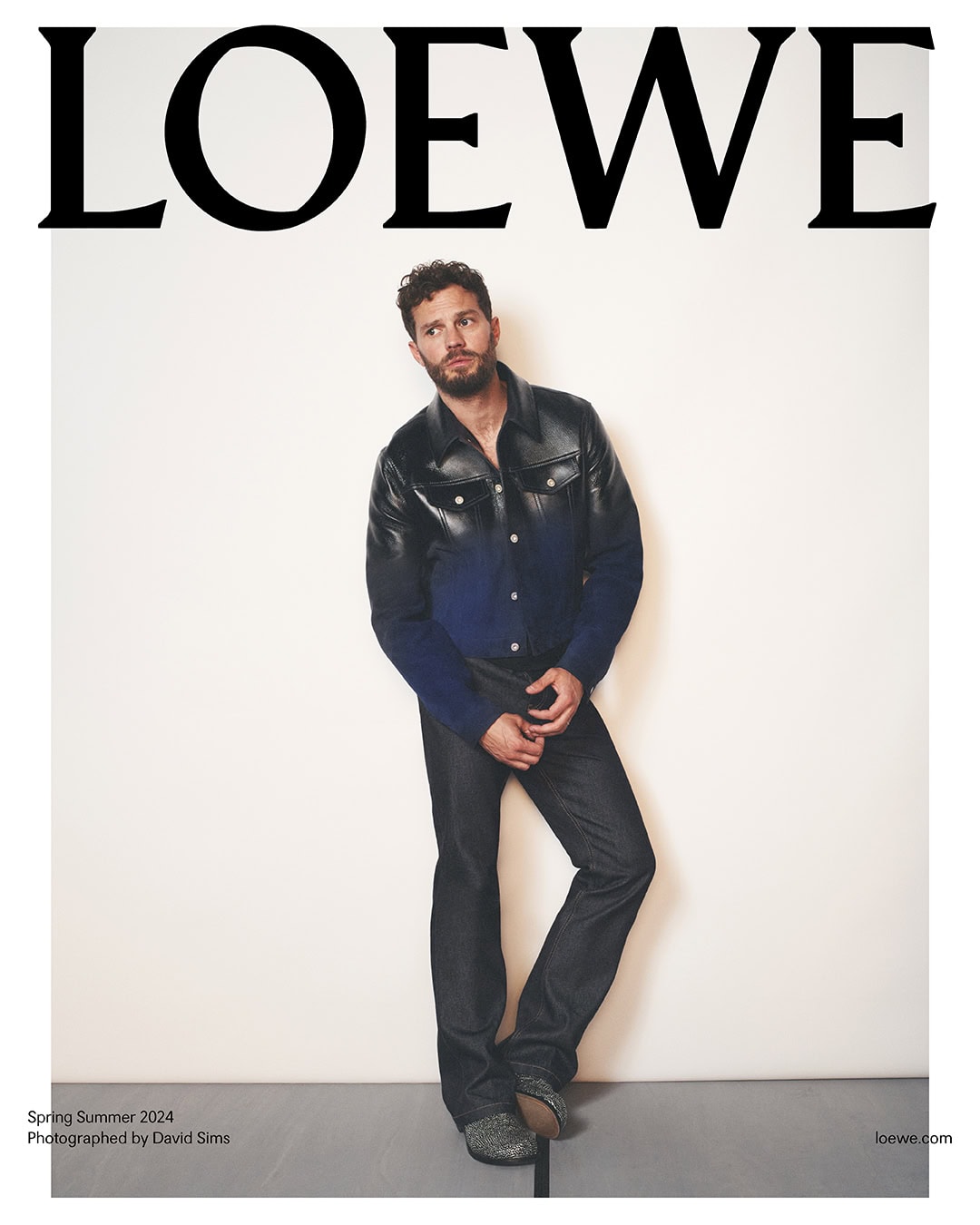 Fashion editorial featuring a male model in a blue collared shirt and black jeans, posing against a plain studio backdrop, with LOEWE logo.