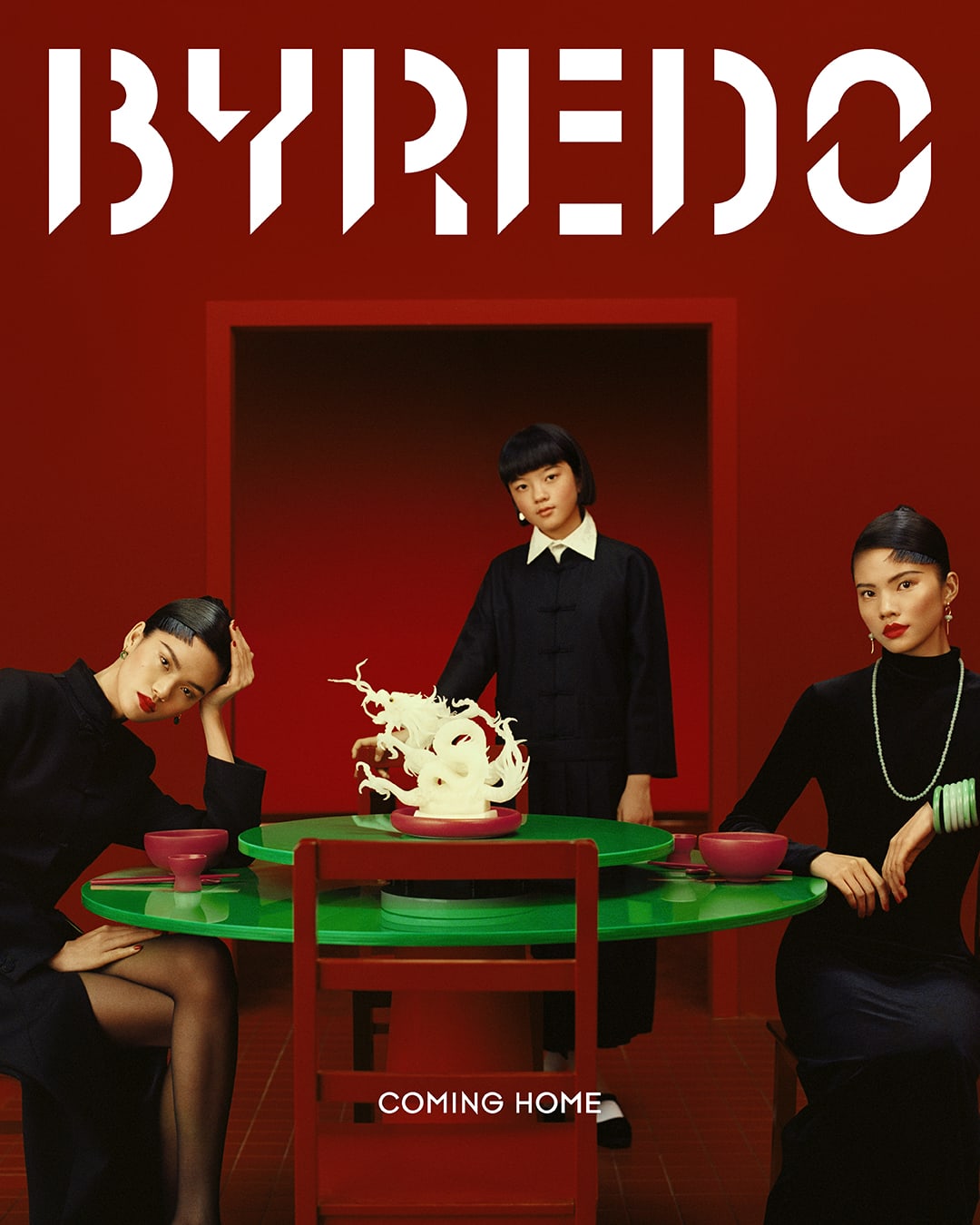 Byredo ad featuring three Asian women in black outfits around a green table with a white sculpture on a red background with text.