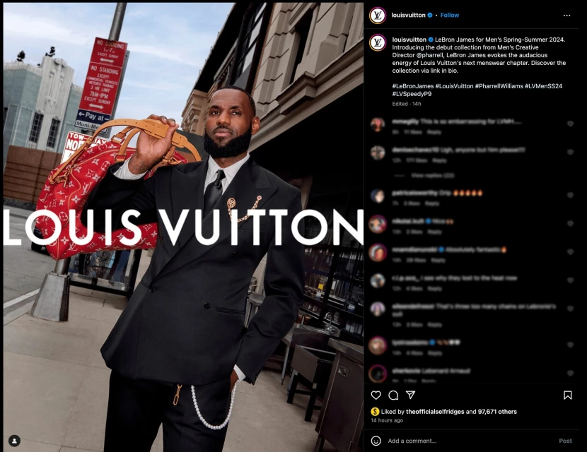 LeBron James in Louis Vuitton menswear collection, posing outdoors with a red LV bag, wearing a black suit and tie.