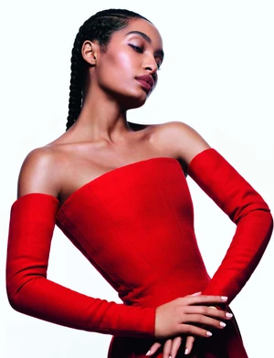 Yara Shahidi wearing a strapless red dress and matching sleeves against a clean white background for Dior.