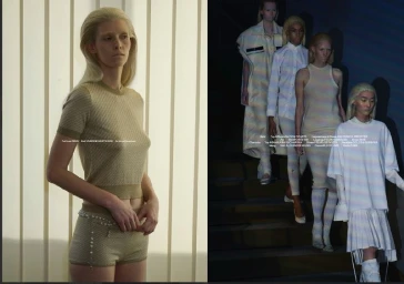 Model wearing a textured knit top and shorts standing against striped vertical architectural panels.
