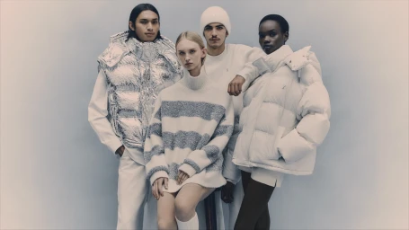 Four models in winter outerwear including a metallic puffer vest and white puffer jacket against a grey background.