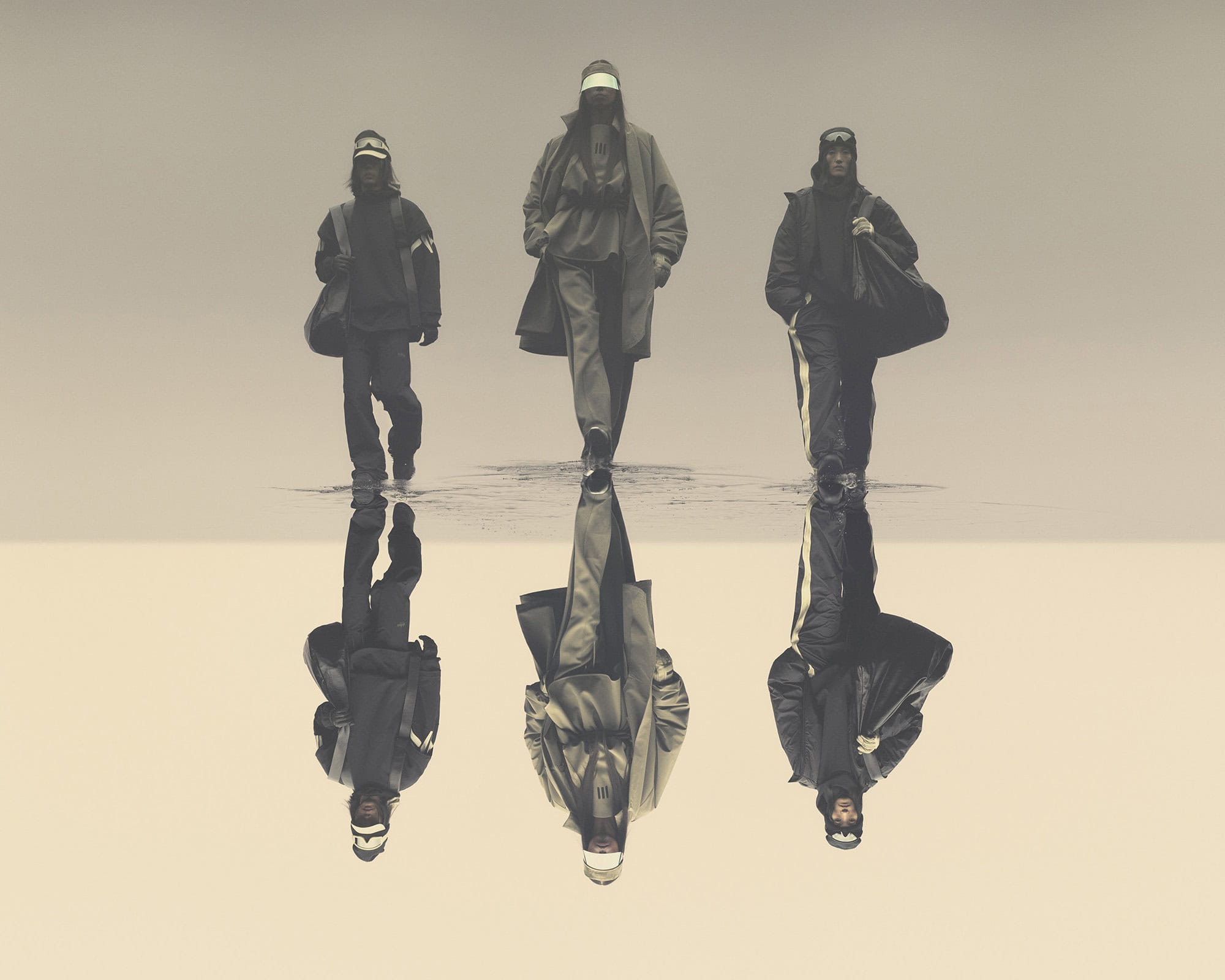 Three people walk toward the viewer in a neutral-toned setting. The figures are reflected on the surface below, creating a mirror effect.