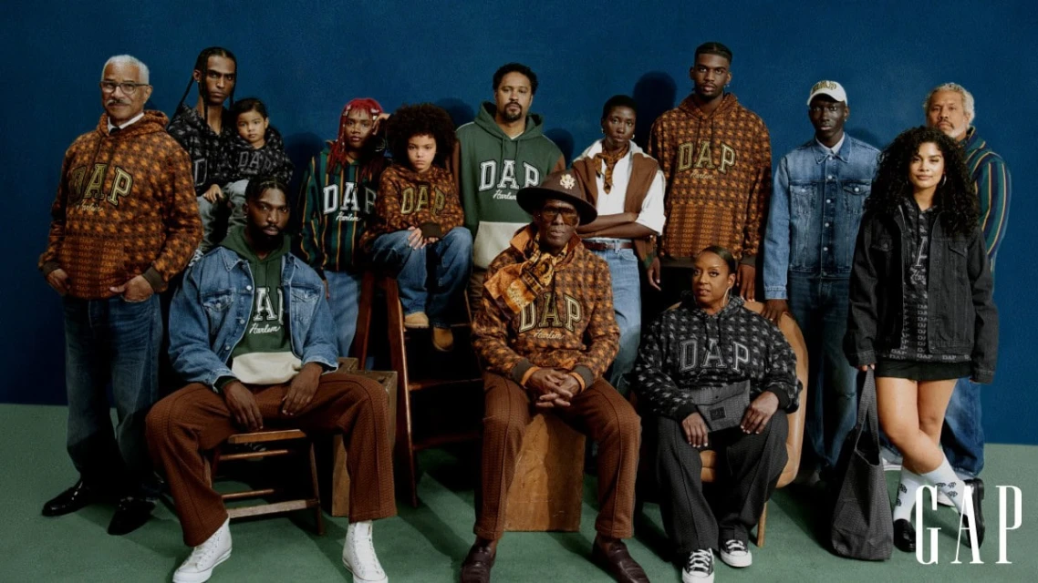 Group of diverse adults and children posing in GAP-branded apparel against a blue backdrop, showcasing urban lifestyle and fashion.