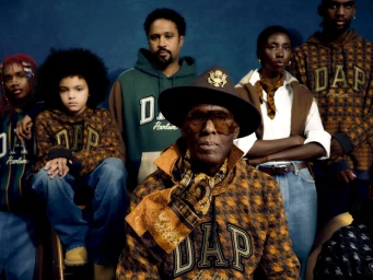 Dapper Dan and ensemble wearing branded hoodies and patterned scarves against a textured blue backdrop