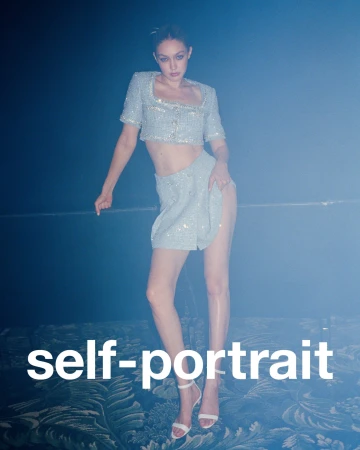 Woman in shimmering crop top and mini skirt posing against a textured blue background, wearing white high heels. Fashion shot, studio lighting.