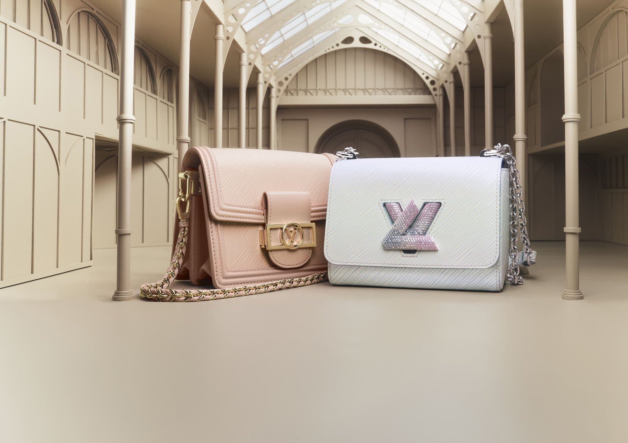 Two fashion handbags by Louis Vuitton are staged in a photo studio with the soft, neutral colour palette creating a refined aesthetic.