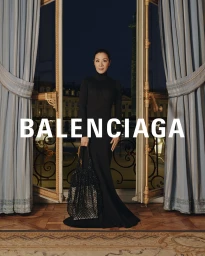 Michelle Yeoh standing inside a hotel room holding a black handbag for Balenciaga Spring 2024 campaign