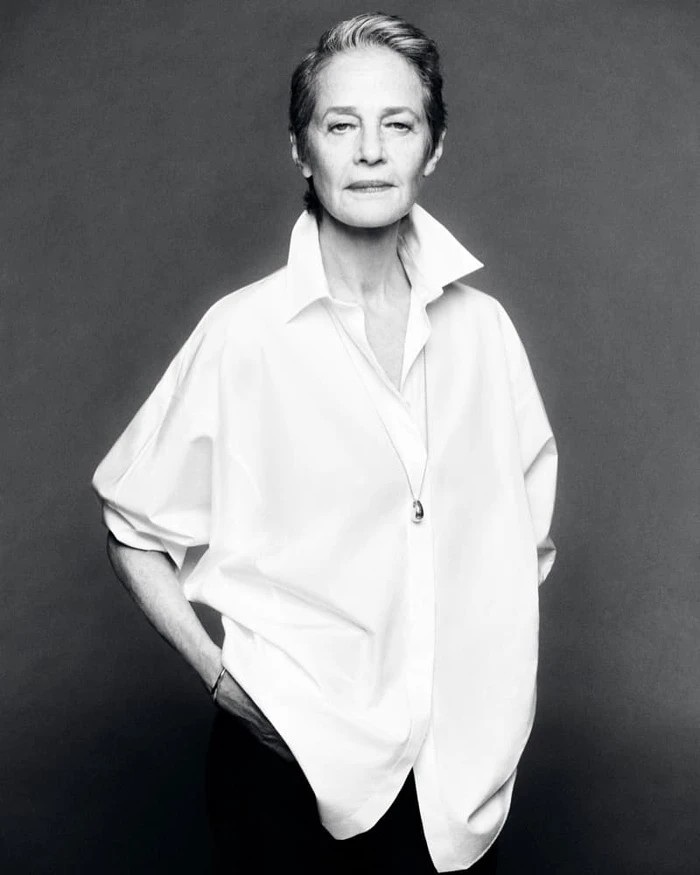 Black and white studio portrait of actress Charlotte Rampling wearing an oversized white shirt.