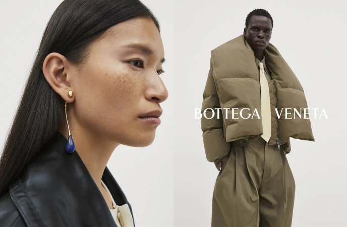 Fashion ad featuring a woman with statement earrings and a man in a puffer coat, both wearing Bottega Veneta apparel against a light backdrop.