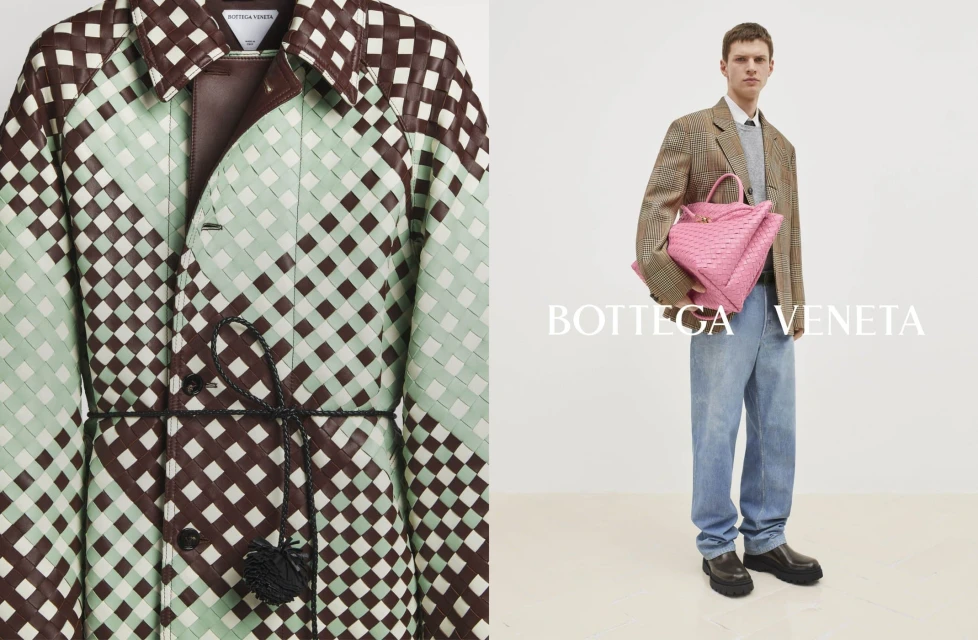 Fashion shot featuring a man holding a pink woven bag, wearing a brown plaid jacket with light wash jeans, and a woven coat on display.