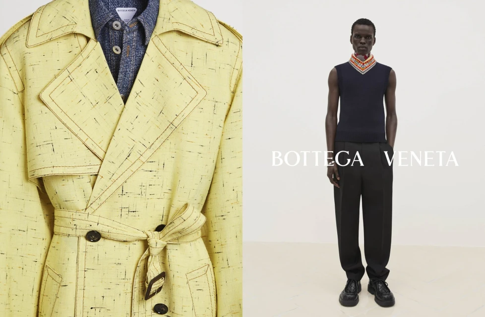 Fashion editorial shot featuring a man modeling Bottega Veneta clothing with a yellow trench coat. The backdrop is a clean, neutral tone.