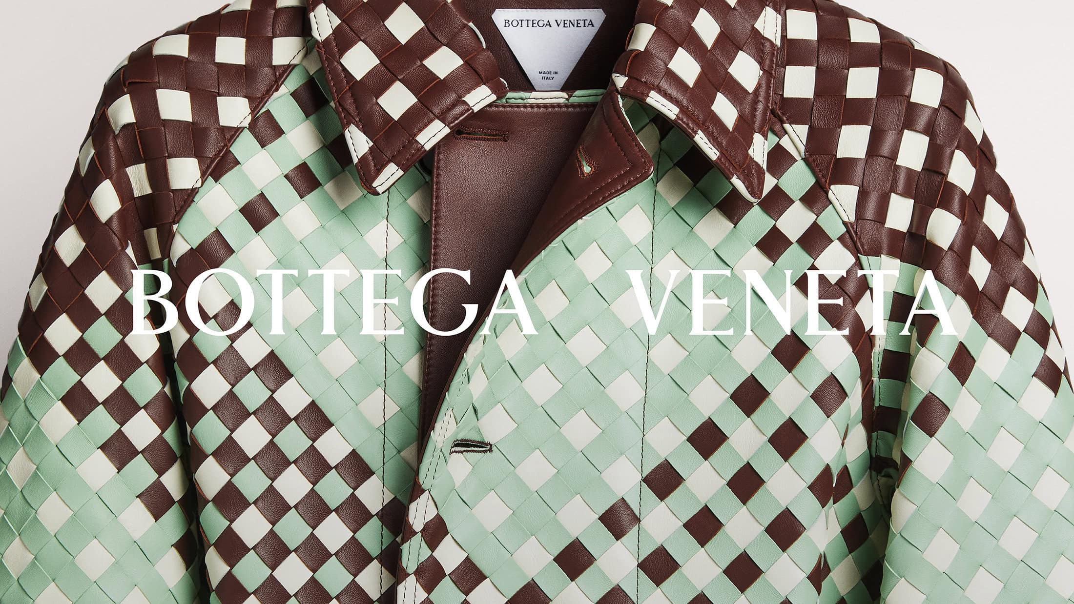 Close-up of a Bottega Veneta jacket featuring a woven pattern with brown and pale green leather, creating an elegant and textured design.