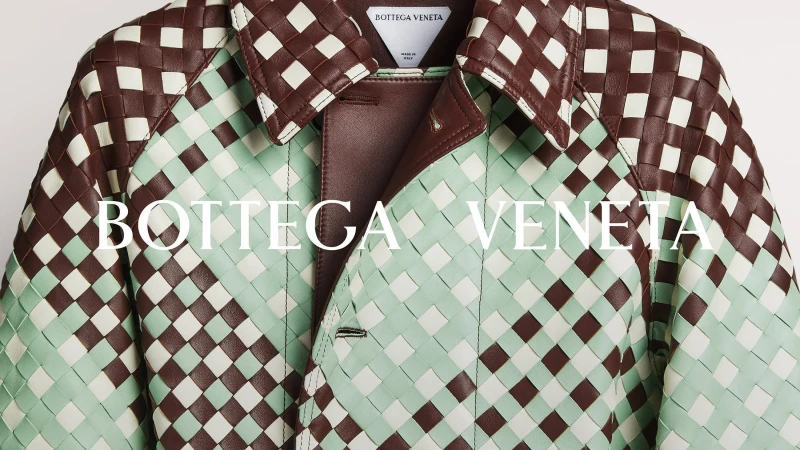 Close-up of a Bottega Veneta jacket featuring a woven pattern with brown and pale green leather, creating an elegant and textured design.